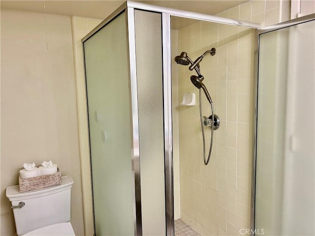 full bathroom featuring a stall shower and toilet