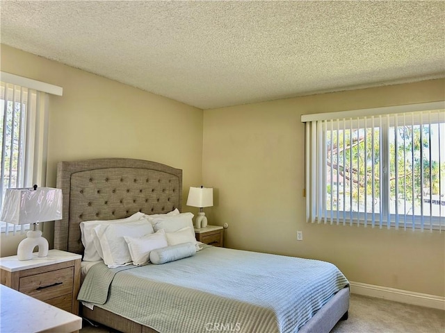 bedroom with baseboards, multiple windows, carpet, and a textured ceiling