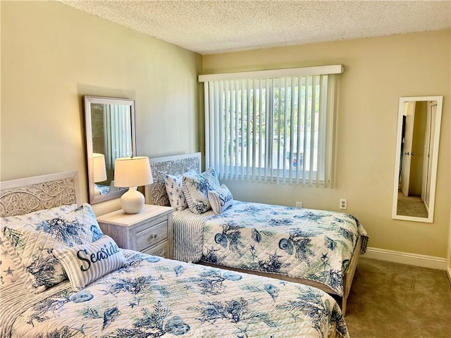 bedroom featuring carpet flooring, baseboards, and a textured ceiling