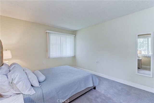 86 Calle Aragon Unit O, Laguna Woods, CA 92637 - carpeted bedroom with baseboards and a textured ceiling