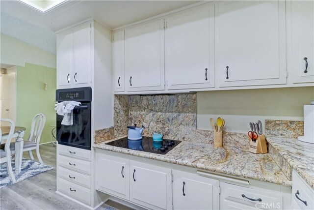 86 Calle Aragon Unit O, Laguna Woods, CA 92637 - kitchen featuring white cabinetry, black appliances, and tasteful backsplash