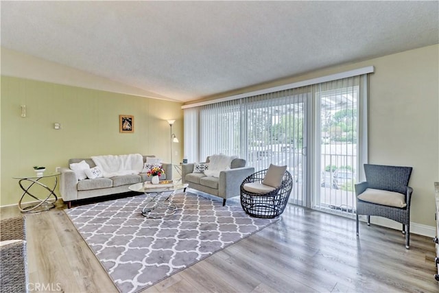 86 Calle Aragon Unit O, Laguna Woods, CA 92637 - living room featuring a textured ceiling, lofted ceiling, and wood finished floors