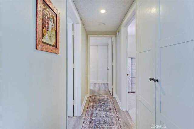 86 Calle Aragon Unit O, Laguna Woods, CA 92637 - corridor with light wood-style floors, a textured ceiling, and baseboards