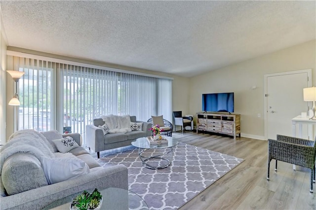 86 Calle Aragon Unit O, Laguna Woods, CA 92637 - living area featuring plenty of natural light, a textured ceiling, lofted ceiling, and wood finished floors