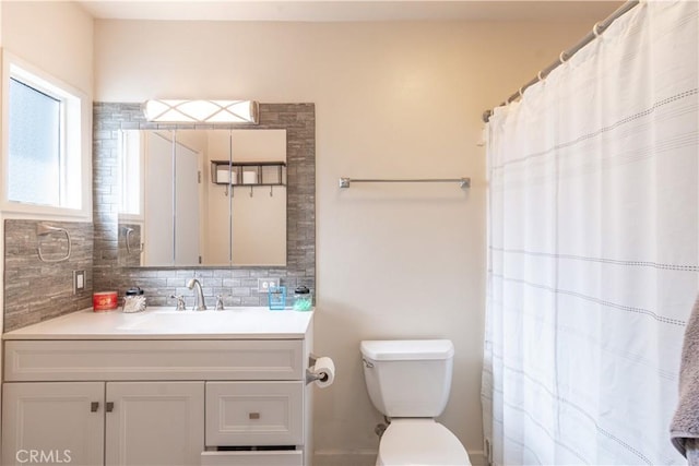 full bath with tasteful backsplash, curtained shower, toilet, and vanity