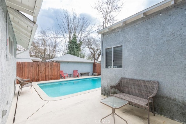 view of swimming pool with a fenced in pool, a patio, and fence