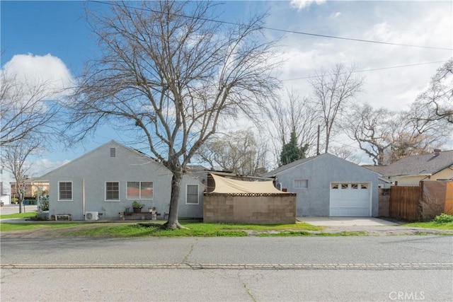 view of home's exterior featuring concrete driveway, fence, a garage, and stucco siding