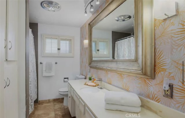full bathroom featuring toilet, vanity, and wallpapered walls
