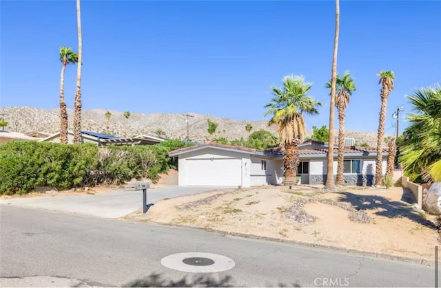 view of front of home featuring a mountain view, concrete driveway, and an attached garage