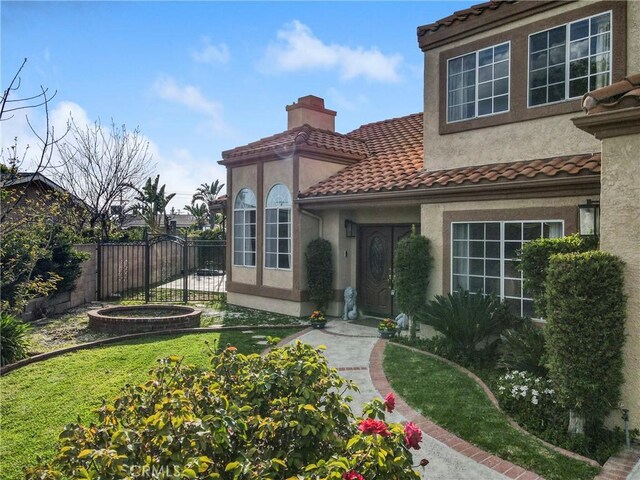 18429 Germain St, Porter Ranch, CA 91326 - view of exterior entry featuring a chimney, stucco siding, and a tiled roof