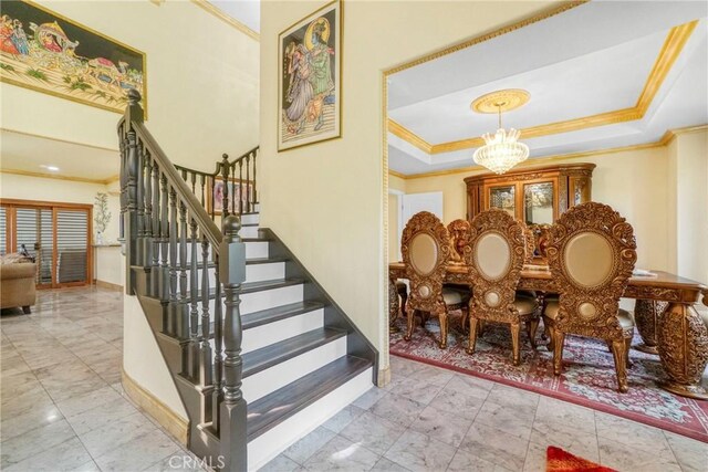 18429 Germain St, Porter Ranch, CA 91326 - stairs with ornamental molding, a chandelier, marble look tile flooring, a tray ceiling, and baseboards