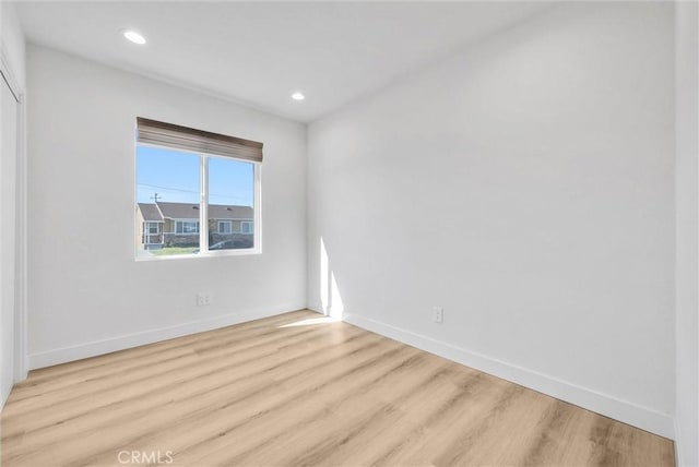 unfurnished room with recessed lighting, wood finished floors, and baseboards