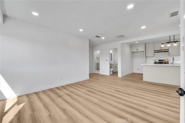 unfurnished living room with visible vents, recessed lighting, and light wood-type flooring