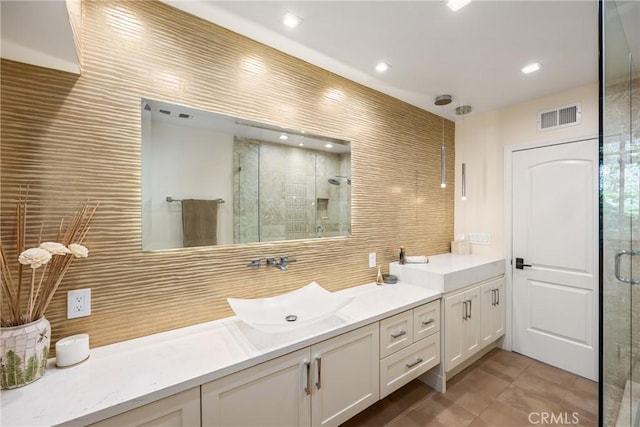 full bath with visible vents, backsplash, tile walls, a stall shower, and vanity