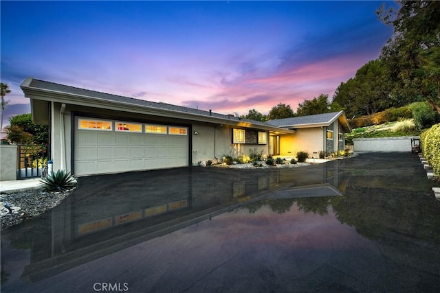 single story home featuring stucco siding, an attached garage, and concrete driveway