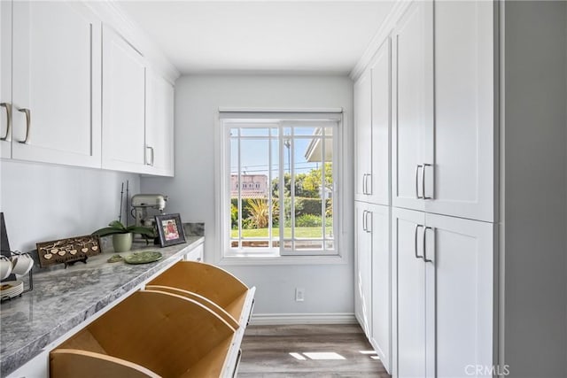 kitchen featuring white cabinets, baseboards, and wood finished floors