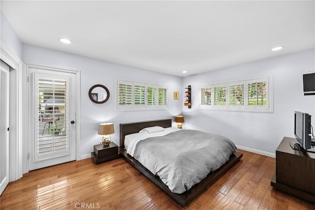 bedroom featuring access to exterior, recessed lighting, light wood-type flooring, and baseboards