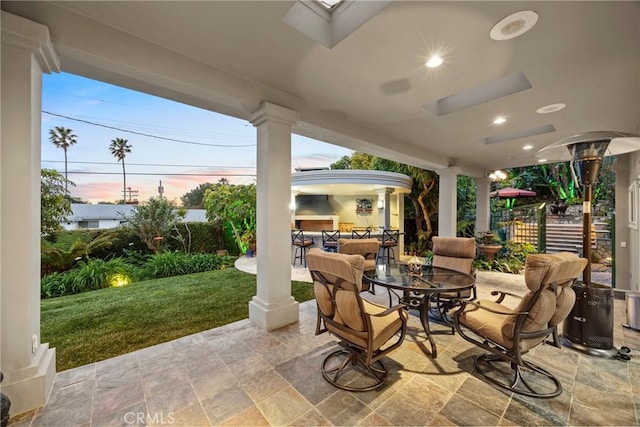 patio terrace at dusk with outdoor dining space and outdoor lounge area