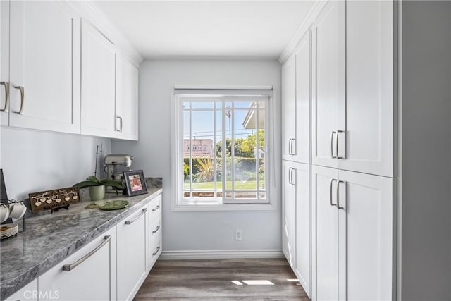 kitchen with white cabinetry, dark wood-type flooring, and baseboards