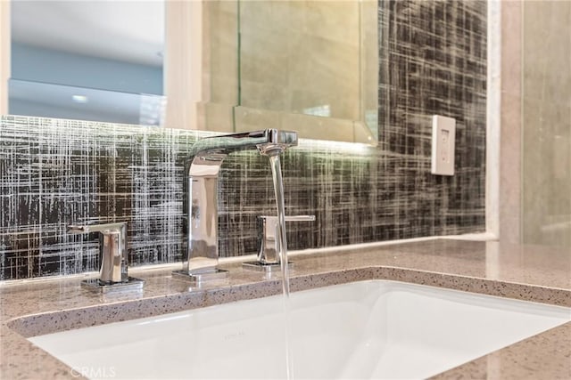 bathroom featuring a sink and backsplash