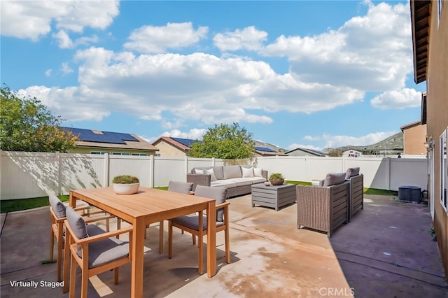 view of patio featuring outdoor dining area, an outdoor hangout area, central AC, and a fenced backyard