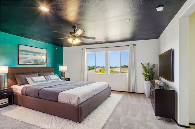 bedroom with light carpet, visible vents, and ceiling fan