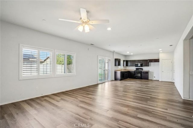 unfurnished living room with recessed lighting, wood finished floors, and ceiling fan