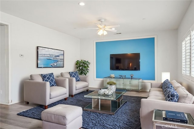 living area with wood finished floors and a ceiling fan