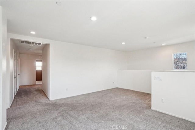 carpeted empty room featuring visible vents and recessed lighting