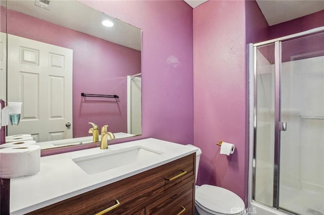 bathroom with visible vents, a shower stall, vanity, and toilet