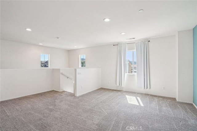 spare room featuring carpet flooring, recessed lighting, visible vents, and baseboards