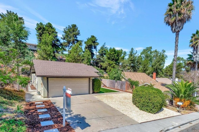 view of front of house with stucco siding, a shingled roof, a garage, and fence