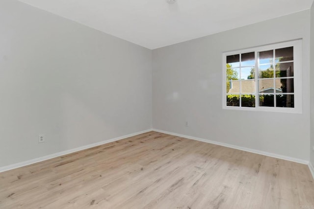 unfurnished room featuring baseboards and wood finished floors