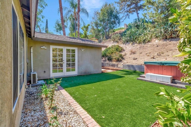 view of yard with french doors, a hot tub, and ac unit