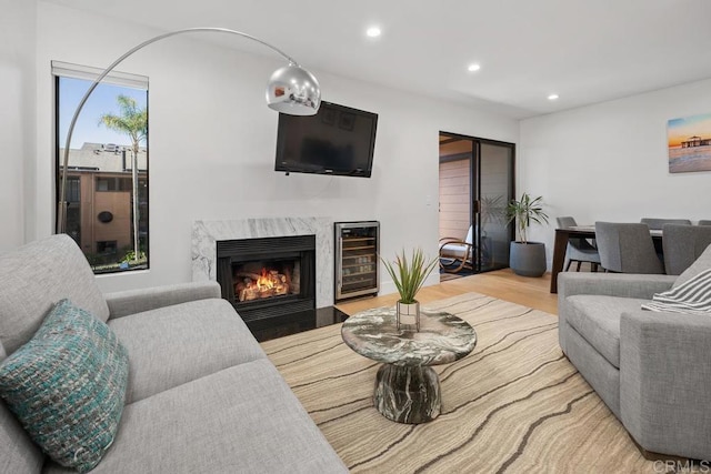 living room featuring recessed lighting, wine cooler, wood finished floors, and a fireplace