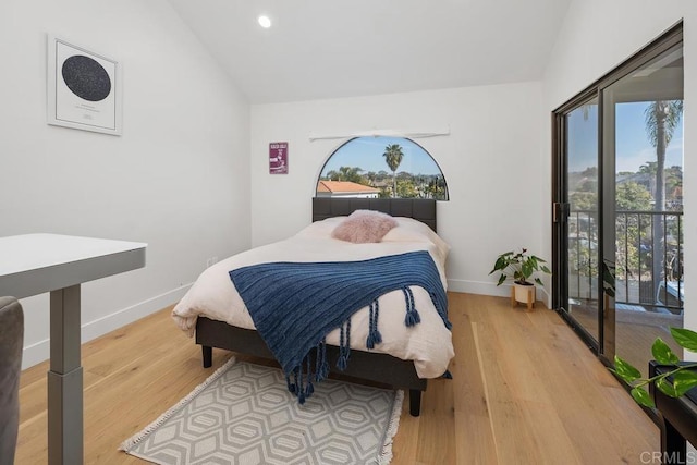 bedroom with lofted ceiling, multiple windows, and wood finished floors