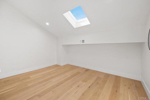 bonus room featuring visible vents, recessed lighting, vaulted ceiling with skylight, light wood finished floors, and baseboards