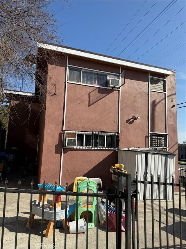 view of side of home with fence and stucco siding