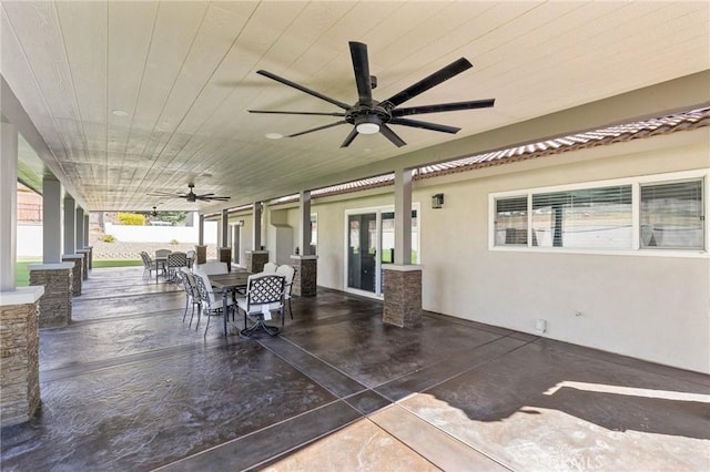 view of patio with outdoor dining area and a ceiling fan