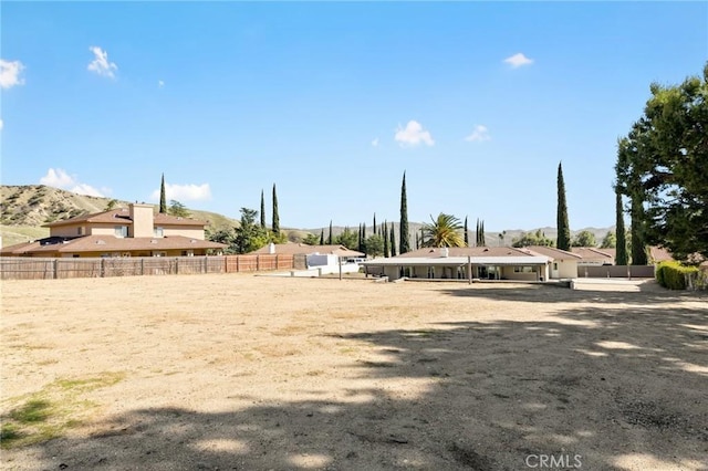 view of yard featuring fence and a mountain view