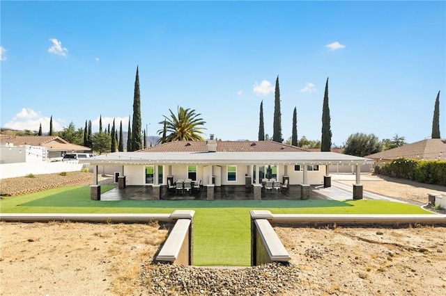 back of house with fence, a lawn, and a patio area