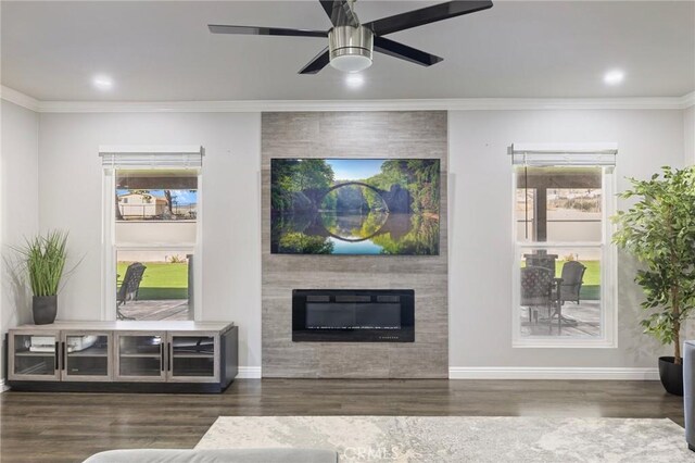 living room featuring baseboards, wood finished floors, a fireplace, and crown molding