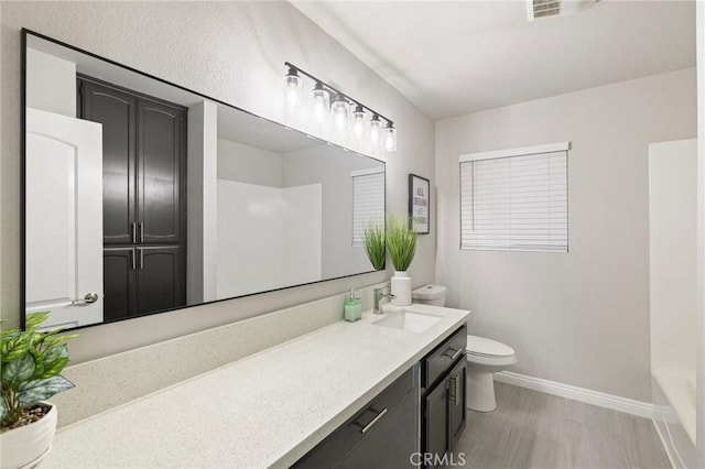 bathroom featuring visible vents, baseboards, toilet, and vanity