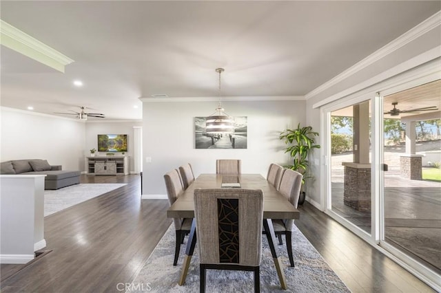 dining area with baseboards, dark wood-type flooring, ornamental molding, and ceiling fan with notable chandelier