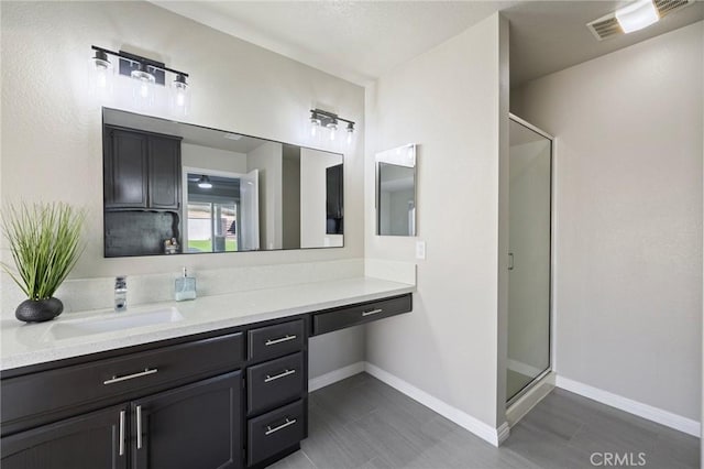 full bathroom featuring visible vents, a stall shower, vanity, and baseboards