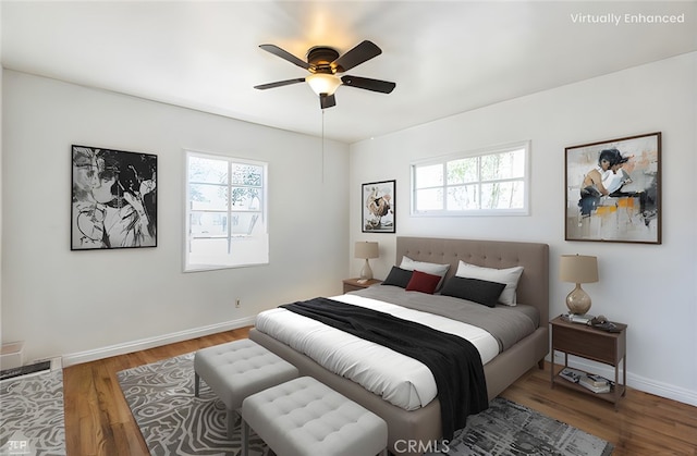 bedroom featuring a ceiling fan, multiple windows, wood finished floors, and baseboards