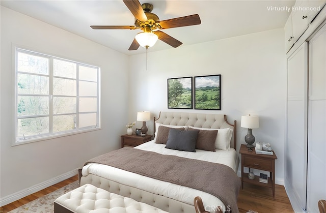 bedroom with wood finished floors, baseboards, and ceiling fan