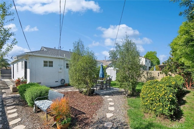 exterior space with stucco siding, fence, and a patio area