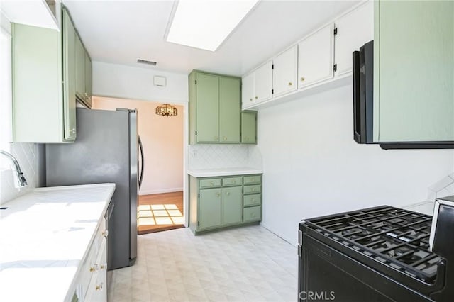 kitchen with visible vents, light floors, green cabinets, and light countertops