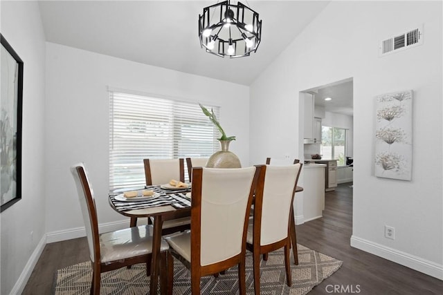 dining space with baseboards, visible vents, lofted ceiling, dark wood-style flooring, and a chandelier